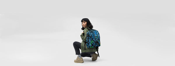 Bild einer knienden jungen Frau mit einem blau grünen Rucksack mit abstrakten Kunstdruck