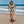 Laden Sie das Bild in den Galerie-Viewer, Frau im schwarz weissen Badeanzug mit Kunstdruck Muster April Zebra am Strand