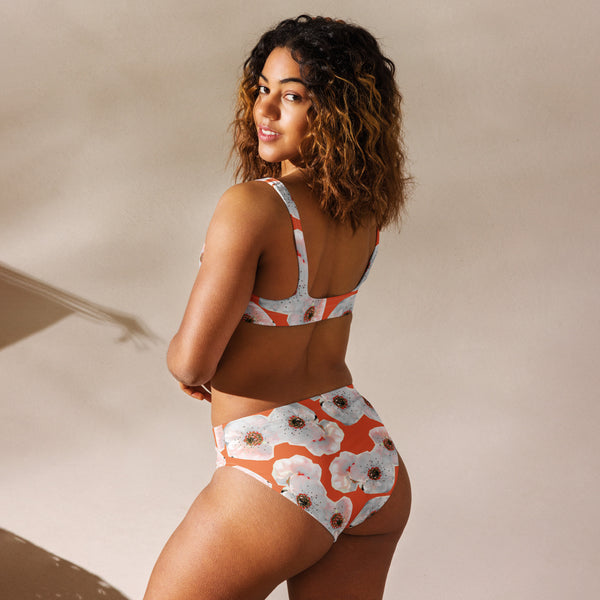 Frau im orangenen Bikini mit Kunstdruck von schräg hinten